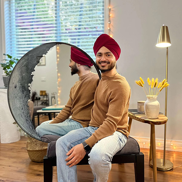 Man sitting in front of moon mirror decor he is proud of
